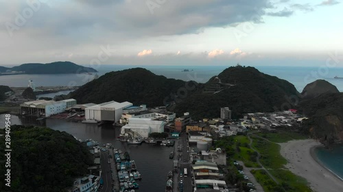 AERIAL: Fishing Harbor With Boats Pan Left Looking Over Coastal Cliffs To Horizon - Taiwan photo