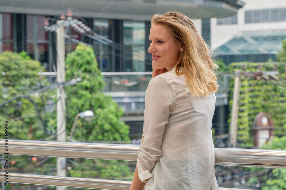 A pretty young woman is walking in the city