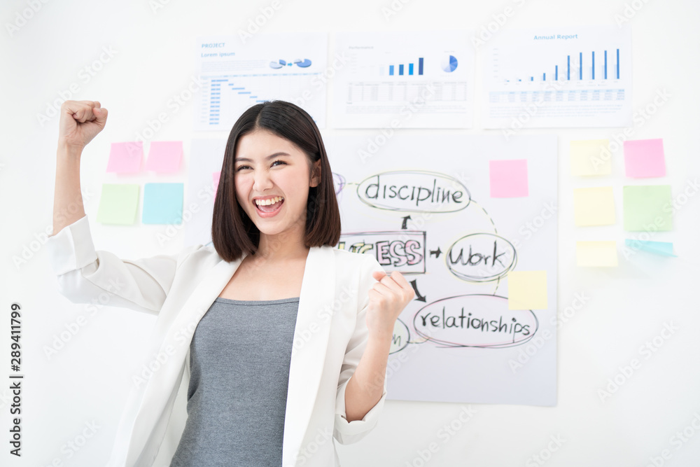 Successful business Asian woman holds her arms up after the great presentation feeling triumphant and happy with the meeting, the concept of strategy and professional presentation