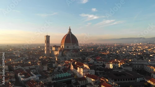 In Florence Italy, the drone pans right and moves left as it highlights the Duomo on a gorgeous sunset. photo