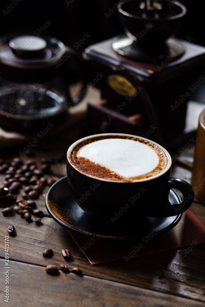 Fototapeta Cup of coffee latte and coffee beans with coffee dripper set on wood table.