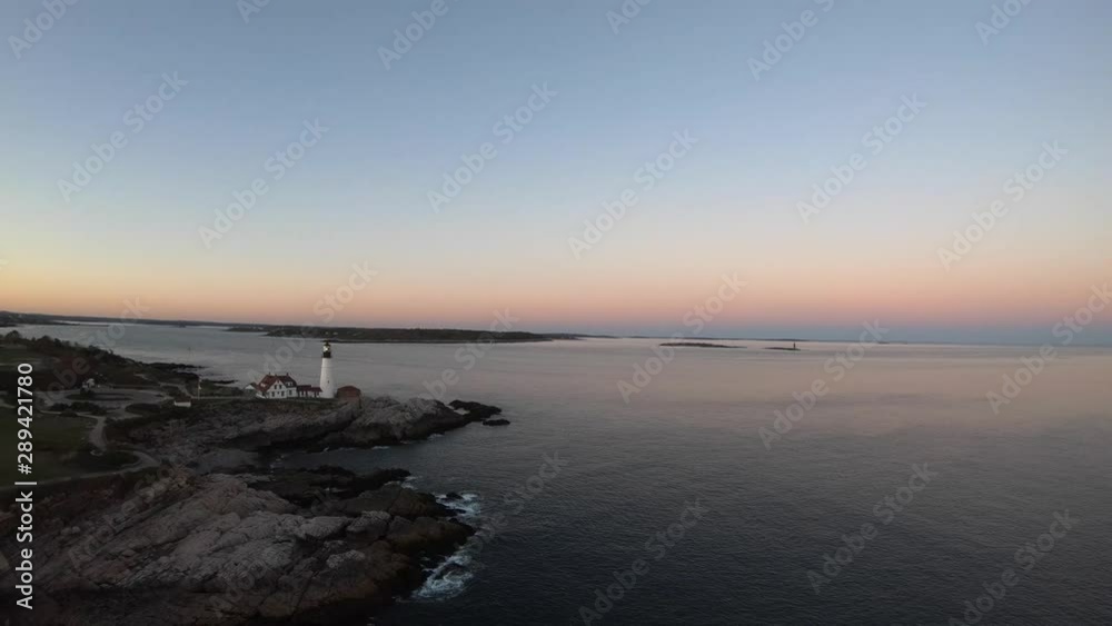 Aerial video of sunset along rocky New England coast with lighthouse Aerial video of sunset along rocky New England coast with lighthouse