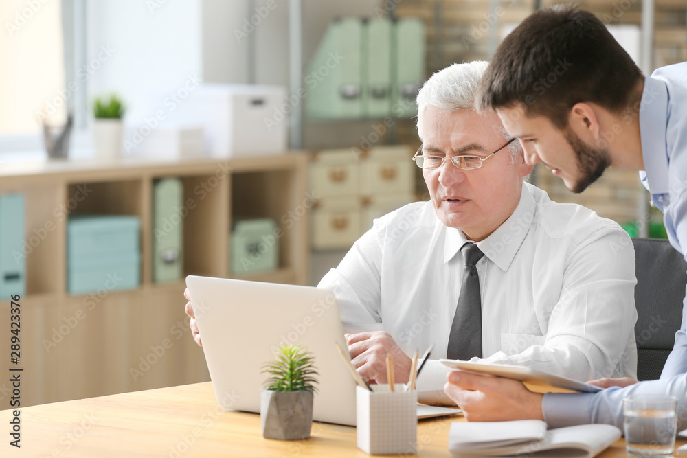 Mature marketing manager with trainee in office Mature marketing manager with trainee in office