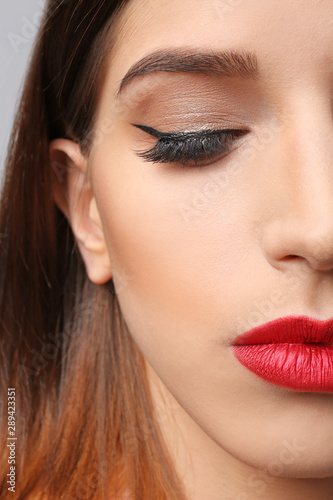 Young woman with elegant makeup and long eyelashes, closeup. Eyelash extensions