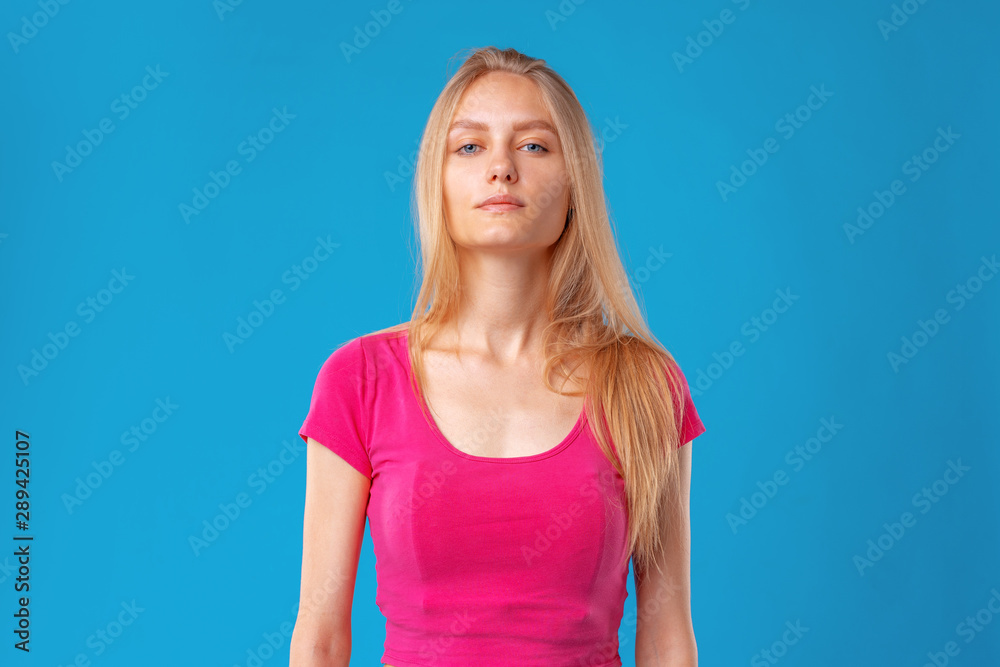 Young attractive blonde caucasian woman portrait on a blue background Young attractive blonde caucasian woman portrait on a blue background