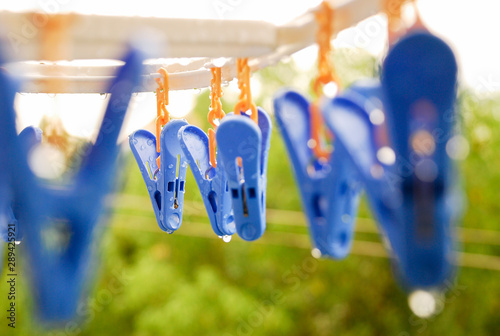 Colored clothespins on plastic hanger in drops after the rain.