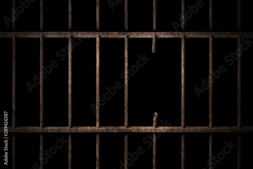 Prison cell with broken old prison bars on black background, way out to freedom