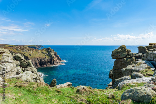 Grassy cliffs overlooking the sea on a partially sunny day in Land’s End, UK. © Hal Photography