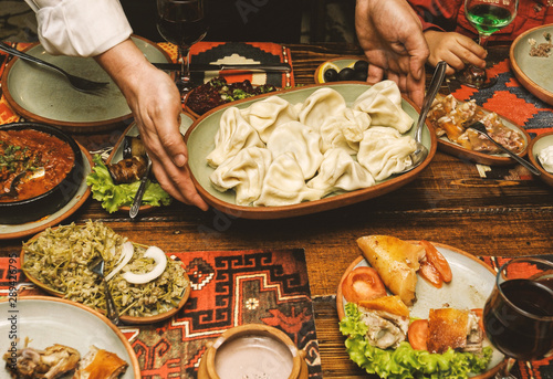 Waiter brings a plate of khinkali.Georgian cuisine.
