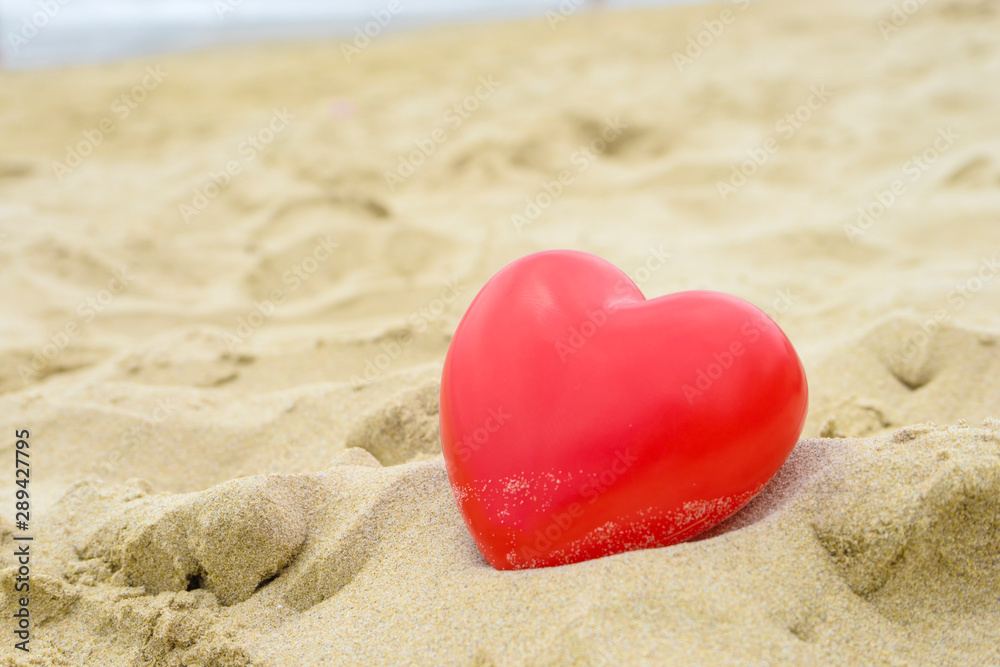Heart on the sand on the summer beach with sea background. Close-up. Heart on the sand on the summer beach with sea background. Close-up.