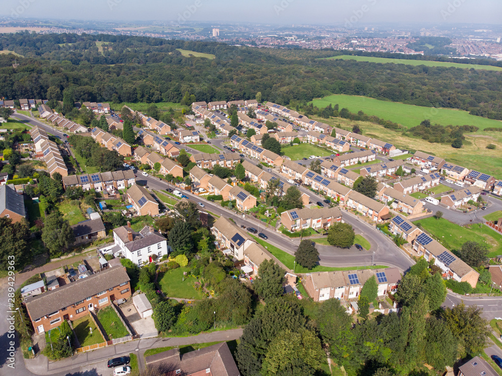 Aerial photo of the British town of Middleton in Leeds West Yorkshire showing typical suburban housing estates with rows of houses, taken on a bright sunny day using a drone.