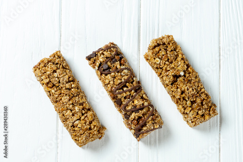 Close up on Granola Bar isolated on white wooden background. Healthy sweet dessert snack. Energy bar of muesli. Granola for breakfast. Copy space