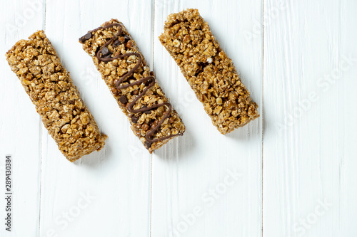 Close up on Granola Bar isolated on white wooden background. Healthy sweet dessert snack. Energy bar of muesli. Granola for breakfast. Copy space
