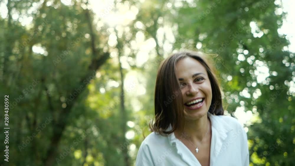 Close up portrait of smiling and joyful feminine girl looking to camera in autumn Park. Attractive young lady is waving his hair, she turns to camera and laughs. Female natural beauty in Slow motion. Close up portrait of smiling and joyful feminine girl looking to camera in autumn Park. Attractive young lady is waving his hair, she turns to camera and laughs. Female natural beauty in Slow motion.