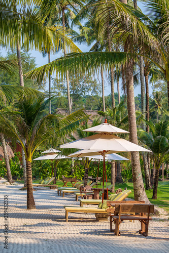 Sun umbrella and beach chairs on tropical coastline for holidays and relaxation , Thailand. Travel and nature concept