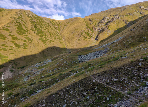 Trans-Ili Alatau mountain range of the Tien Shan system in Kazakhstan near the city of Almaty. Rocky peaks covered with snow and glaciers in the middle of summer under clouds