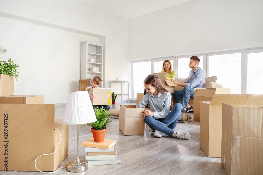 Happy family unpacking belongings in their new house Happy family unpacking belongings in their new house