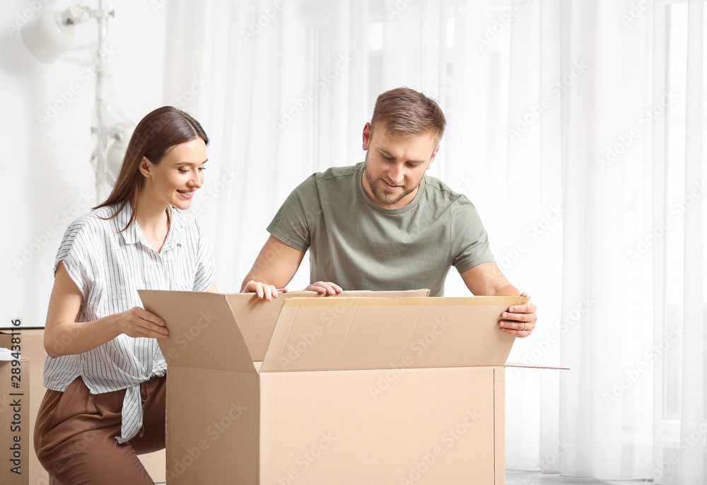 Young couple unpacking things after moving into new house Young couple unpacking things after moving into new house