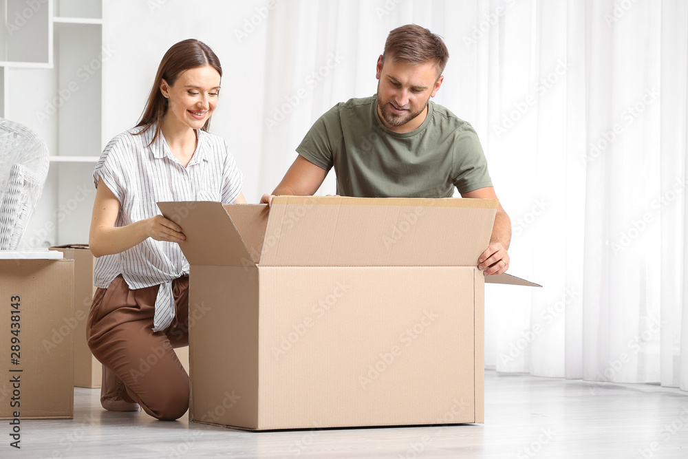 Young couple unpacking things after moving into new house