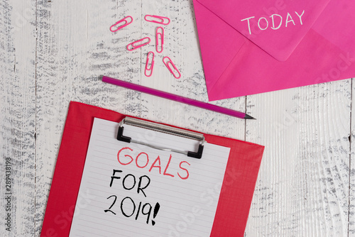 Conceptual hand writing showing Goals For 2019. Concept meaning object of demonstratings ambition or effort aim or desired result Colored clipboard paper sheet pencil clips wooden background