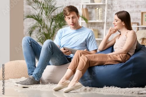 Fotografie Young couple with tablet computer relaxing at home