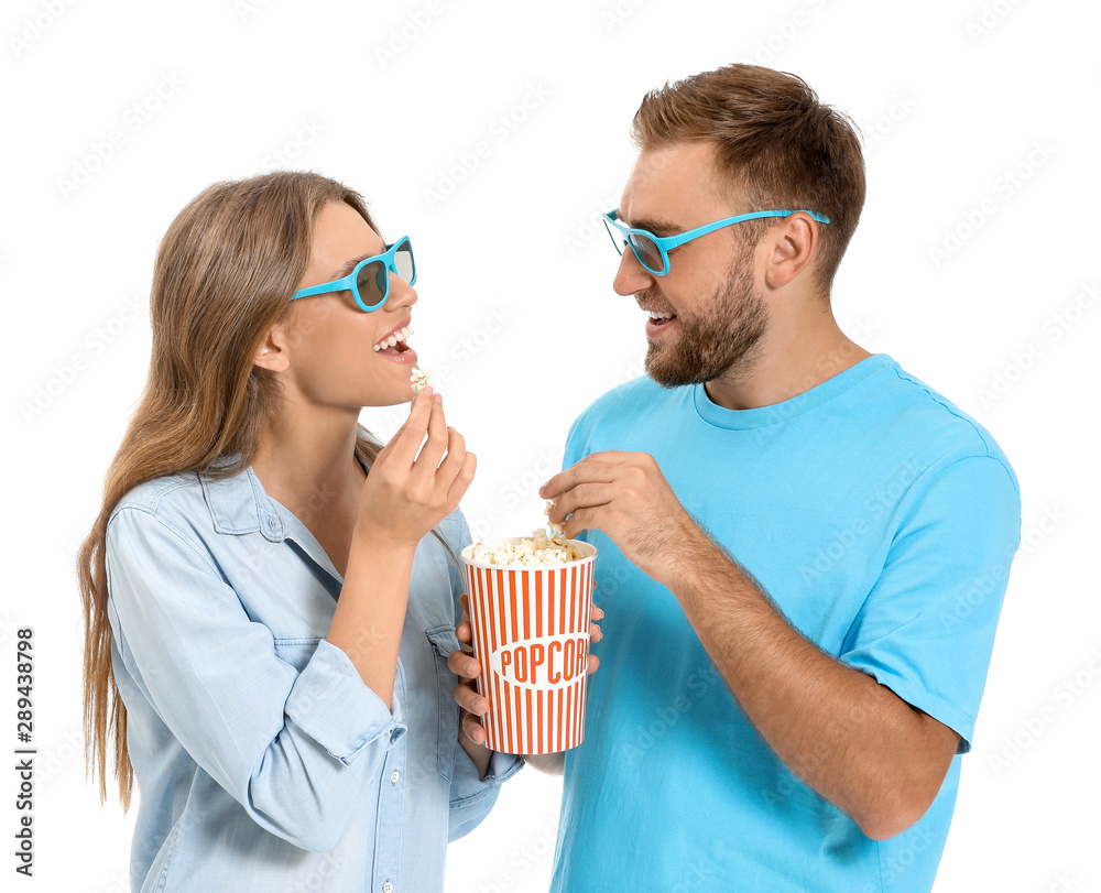 Young couple eating popcorn on white background