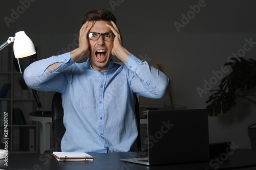 Stressed young man at workp...