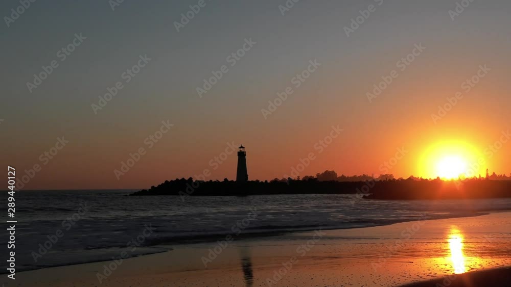 The Pacific Ocean at the Santa Cruz Breakwater (aka Walton) Lighthouse at sunset, in Santa Cruz, California, USA