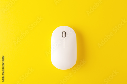 Wireless mouse on yellow background photo