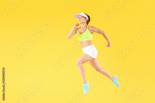 Running female tennis player on color background