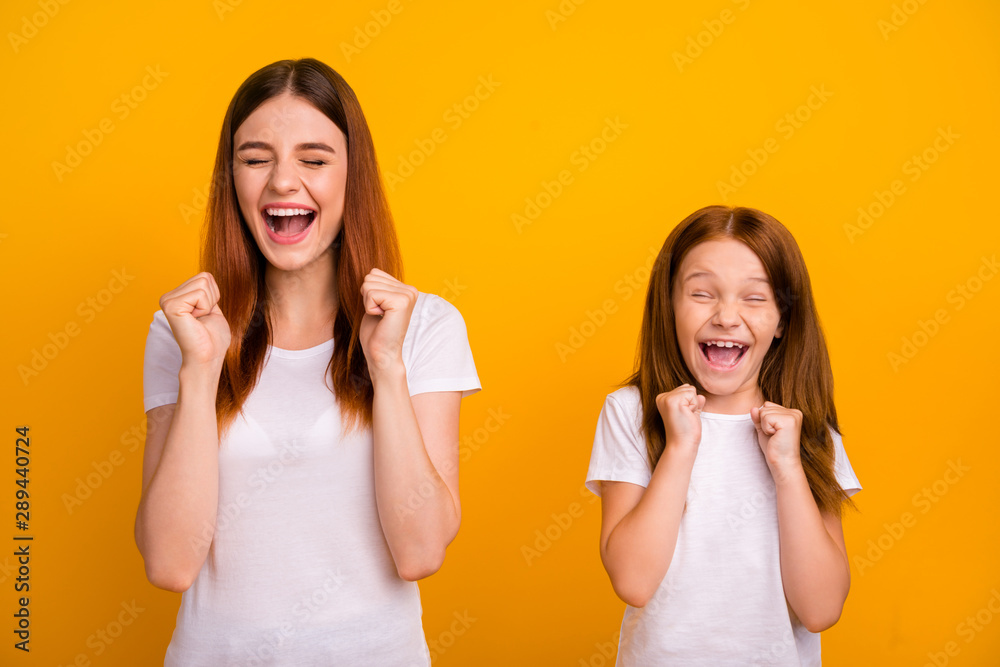 Portrait of cheerful crazy people with long hair screaming raising fists wearing white t-shirt isolated over yellow background Portrait of cheerful crazy people with long hair screaming raising fists wearing white t-shirt isolated over yellow background