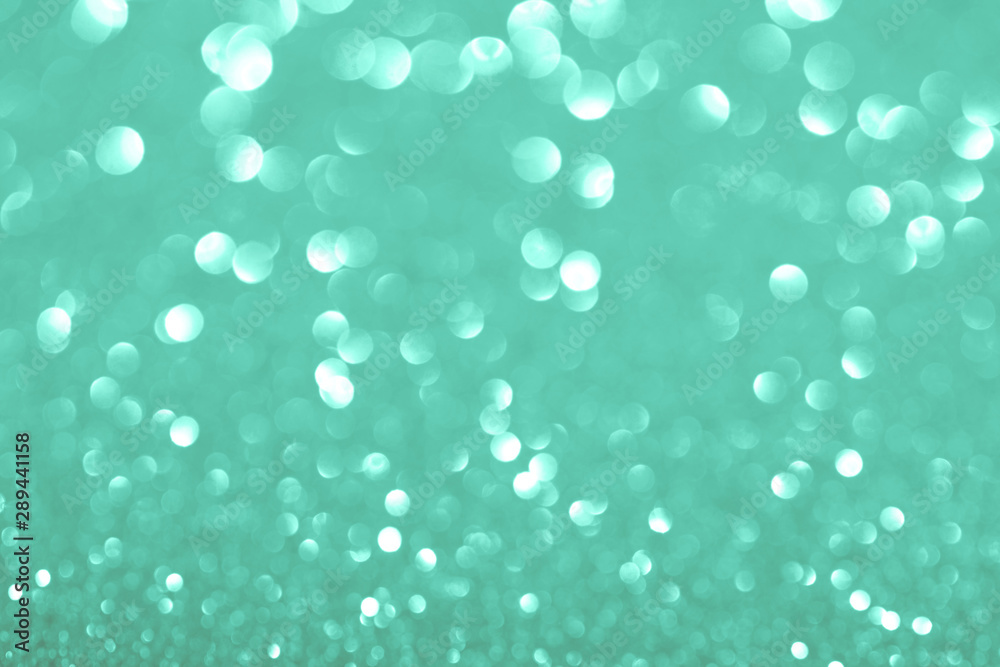 Green festive background with sparkles in the bokeh. The concept of the celebration, the day of St. Valentine, New Year, birthdays, ceremonies, events, etc.