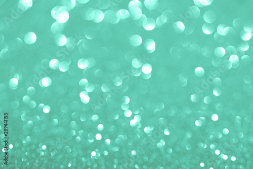 Green festive background with sparkles in the bokeh. The concept of the celebration, the day of St. Valentine, New Year, birthdays, ceremonies, events, etc.