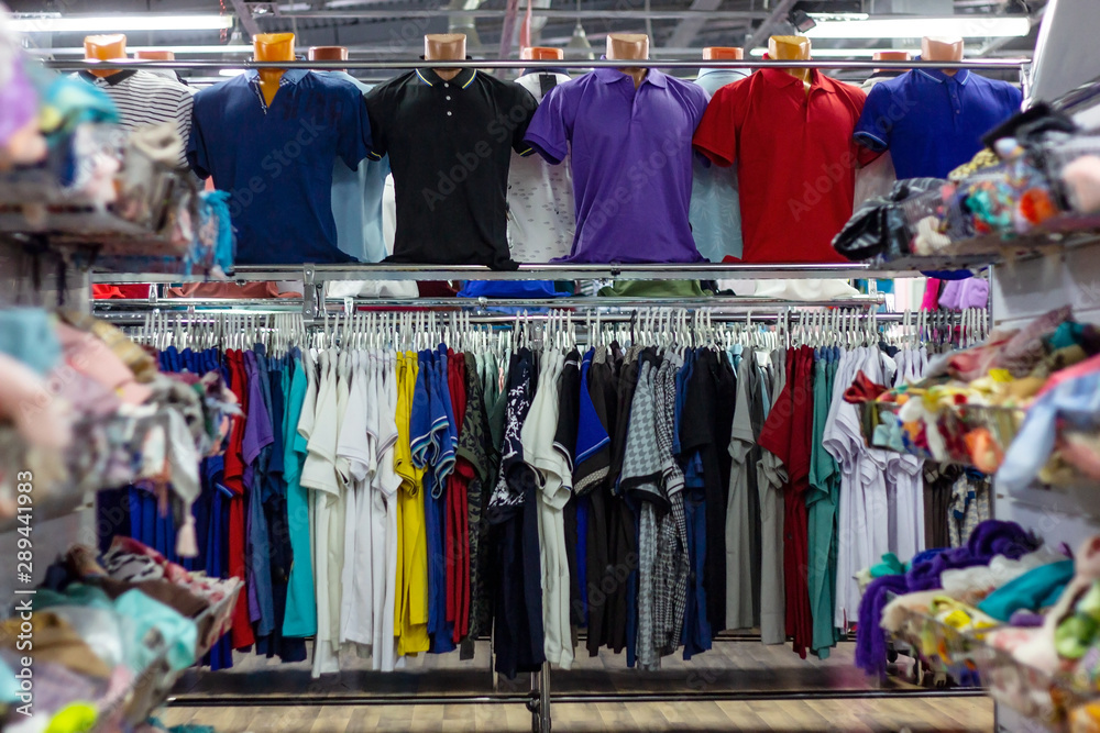 Many different colorful clothes on a hanging rack in the retail shop store. Soft selective focus photography Many different colorful clothes on a hanging rack in the retail shop store. Soft selective focus photography