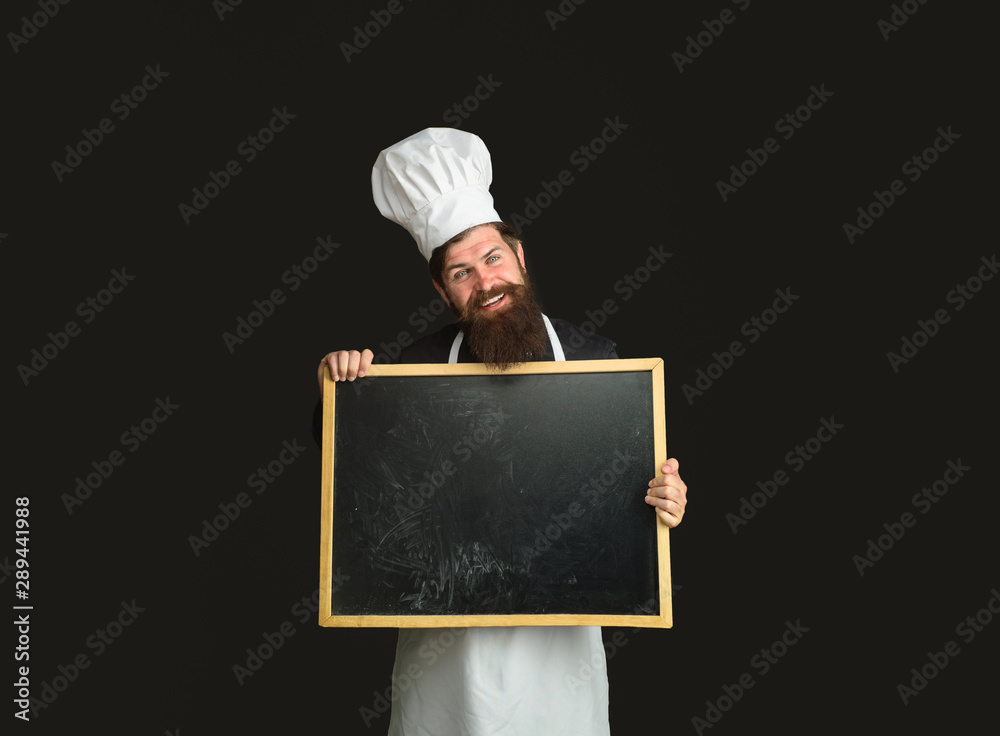Restaurant or cafe menu. Handsome cook holds blank board. Bearded man cook or chef holds empty board in cooking school. Master cook giving cooking class. Chef teaching master class. Place for text.