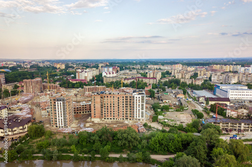 Top view of urban developing city landscape with tall apartment buildings and suburb houses. Drone aerial photography.