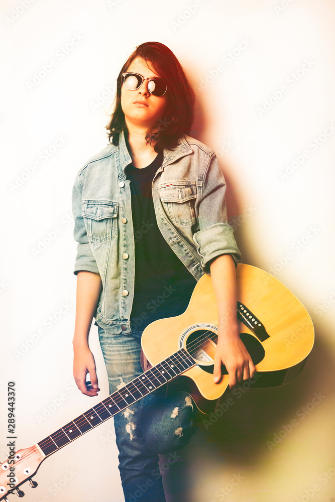Portrait of a teenager playing guitar in studio. Portrait of a teenager playing guitar in studio.