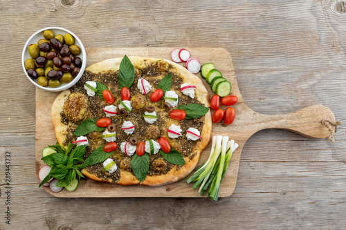 lebanese Manoushe ,bread of thyme topped with mint, reddish, and Labneh; Lebanese Zaatar Manouche; zaatar flat bread photo