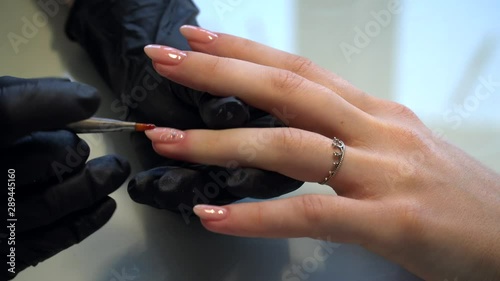 Manicured Nail Art. Beautiful nail Art Manicure.Delicate spring manicure. Woman in a salon receiving a manicure by a beautician. Nail designs with decoration. Manicure nail paint.  