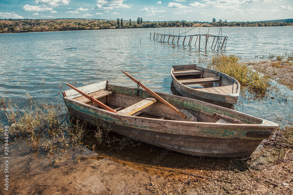 two wooden fishing boats on the river shore 