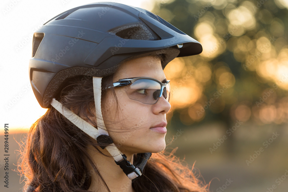 Girl on a mountain bike on offroad, beautiful portrait of a cyclist at sunset, Fitness girl rides a modern carbon fiber mountain bike in sportswear, a helmet, glasses and gloves. Girl on a mountain bike on offroad, beautiful portrait of a cyclist at sunset, Fitness girl rides a modern carbon fiber mountain bike in sportswear, a helmet, glasses and gloves.
