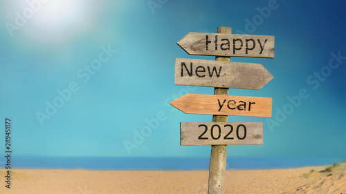 wooden signpost happy new year 2020 on the sky and beach background