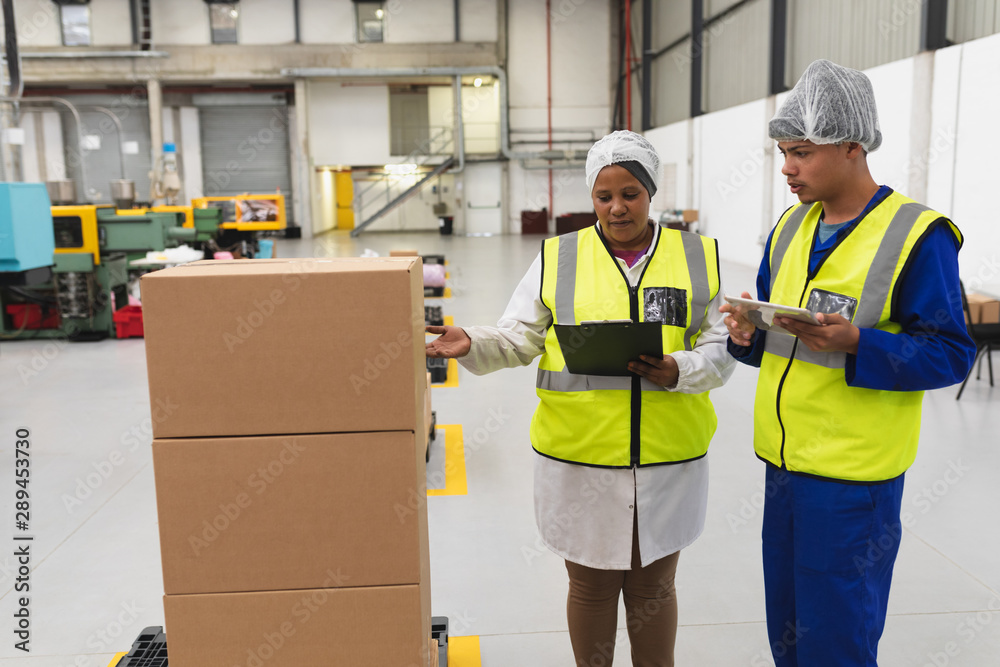 Factory workers talking in a factory warehouse