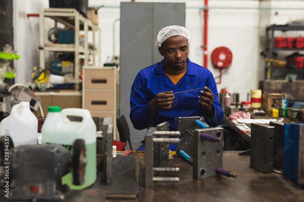 Male factory worker in the workshop at a factory Male factory worker in the workshop at a factory