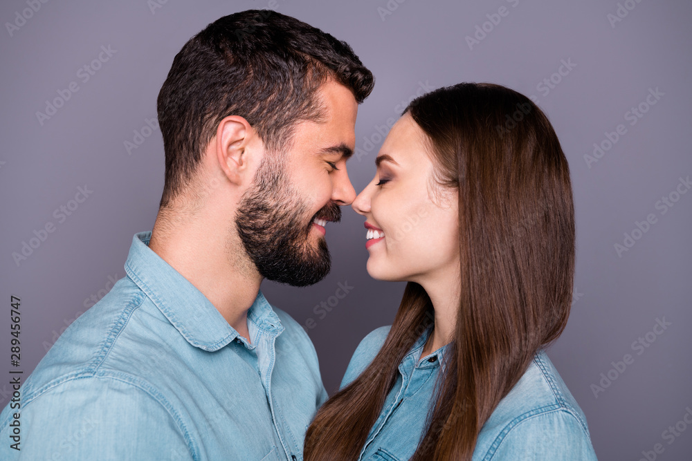Close-up profile side view portrait of two her she his he nice attractive charming lovely lovable careful gentle sweet tender cheerful cheery person cuddling isolated over gray pastel background