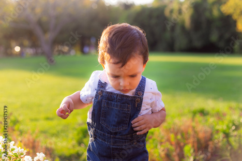 Fotografi Toddler struggling to pass a hinder in green meadow