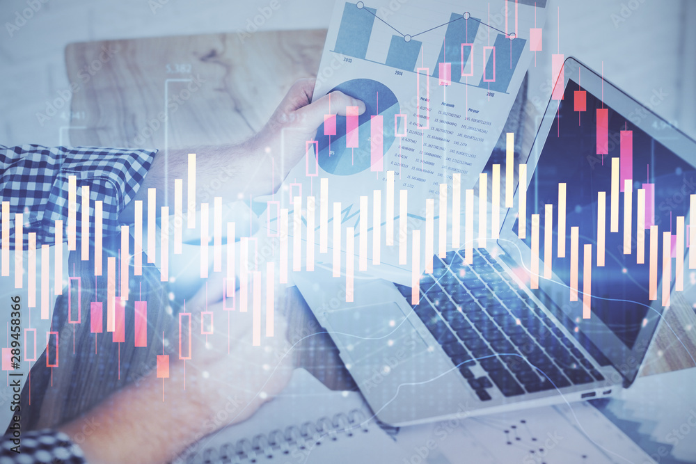Double exposure of man's hands writing notes of stock market with forex graph background. Concept of research and trading. Double exposure of man's hands writing notes of stock market with forex graph background. Concept of research and trading.