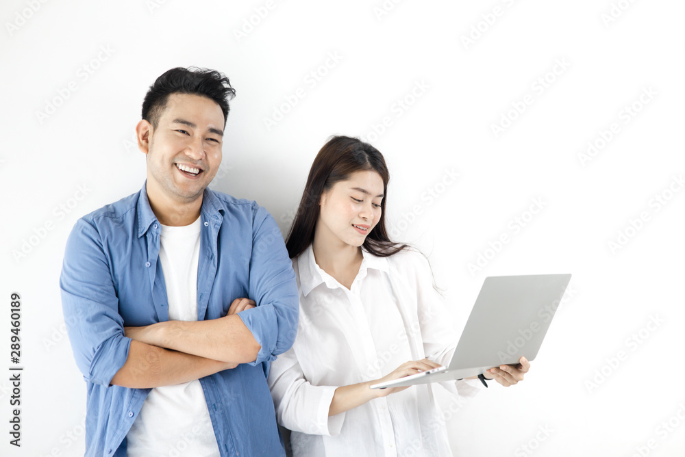 Happy Asian couple using laptop against white wall, lifestyle concept. Happy Asian couple using laptop against white wall, lifestyle concept.
