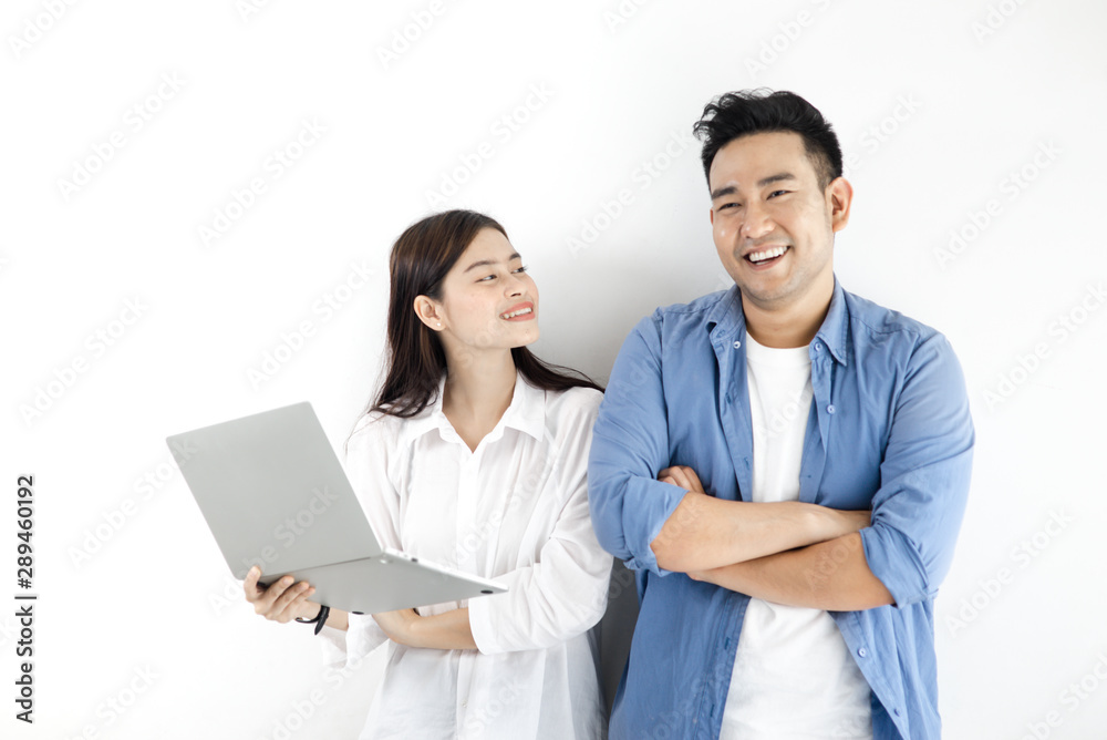 Happy Asian couple using laptop against white wall, lifestyle concept. Happy Asian couple using laptop against white wall, lifestyle concept.