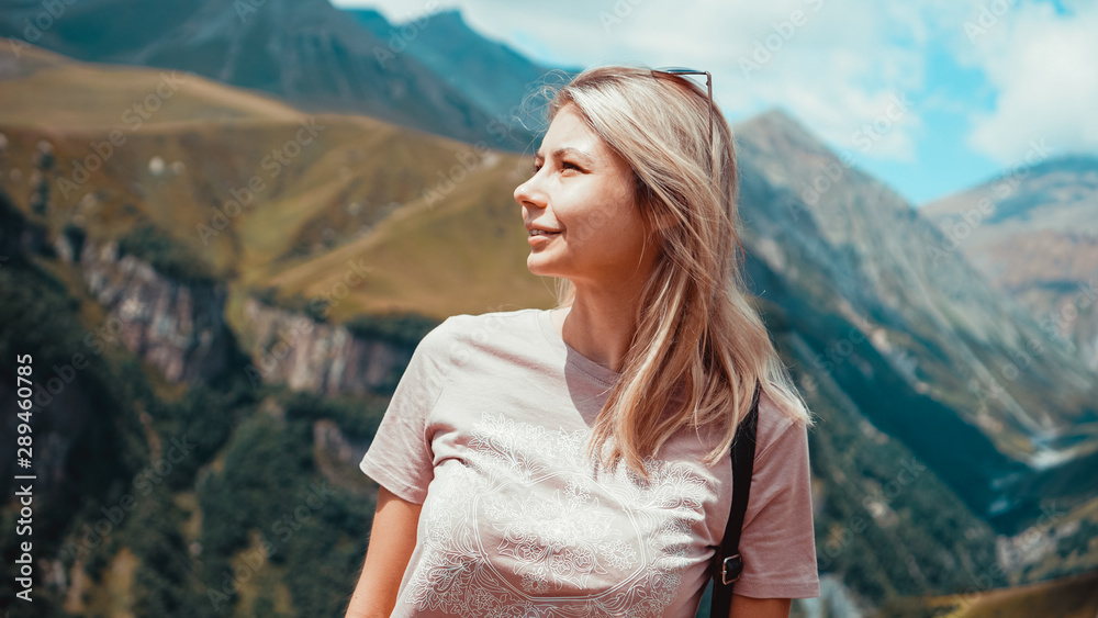 Woman hiking in mountains at sunny day time. View of Kazbegi, Georgia. Beautiful natural mountain background Woman hiking in mountains at sunny day time. View of Kazbegi, Georgia. Beautiful natural mountain background